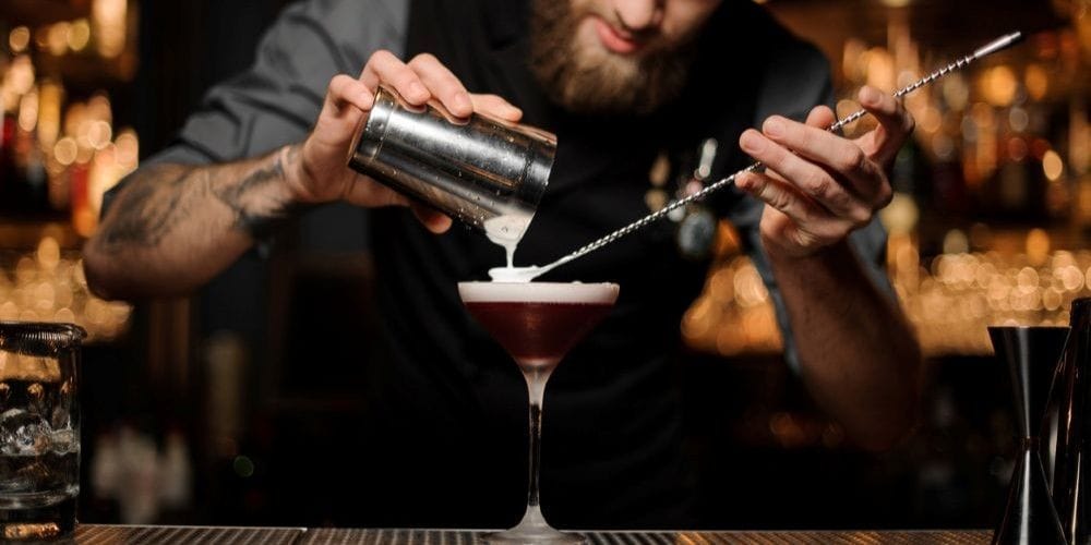 Bartender creating an alcoholic cocktail drink.