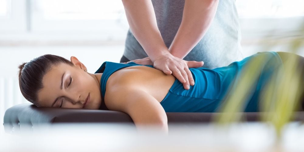 Woman getting an adjustment from a chiropractor.